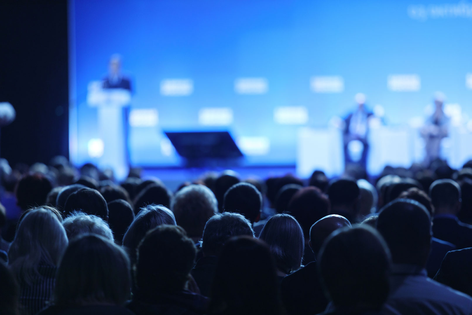 Audience attending a medical conference , with expert speakers on stage discussing innovations in thrombolytic therapy and cardiovascular care.